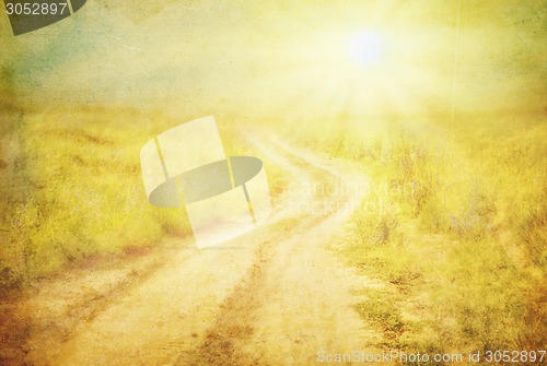 Image of The road through the field at sunset.