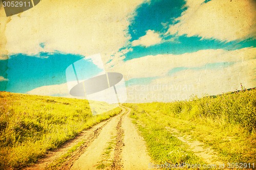 Image of The road through the field at sunset.