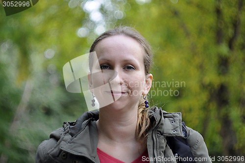 Image of Portrait of the beautiful woman against autumn leaves.