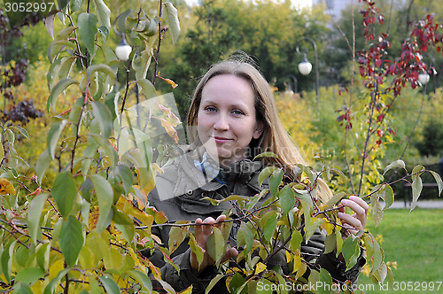 Image of Portrait of the beautiful woman against autumn leaves.