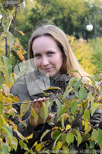 Image of Portrait of the beautiful woman against autumn leaves.