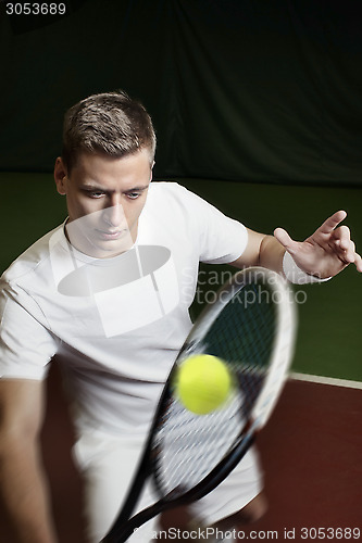 Image of Young man playing tennis