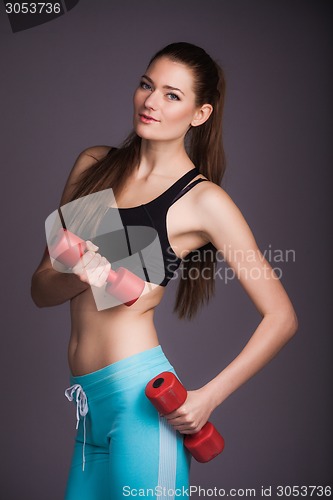 Image of Portrait of young woman with dumbbells