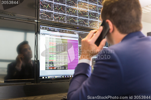 Image of Stock trader looking at computer screens.