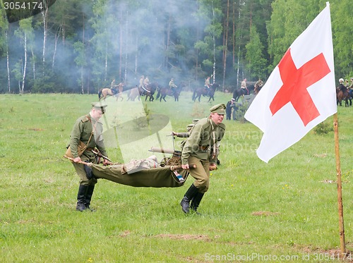 Image of men of medical squad move a wounded soldier