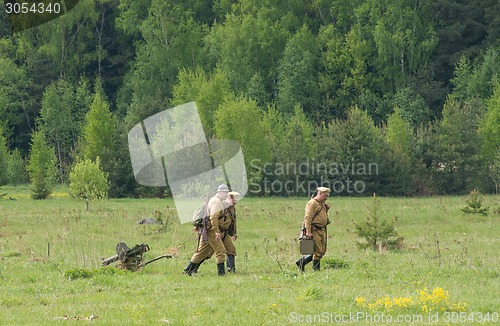 Image of Soldiers walk with Maxim machine gun