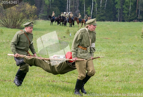 Image of men of medical squad move a wounded soldier