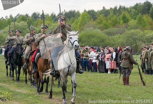 Image of Cavalry soldiers ride on horses with naked swords