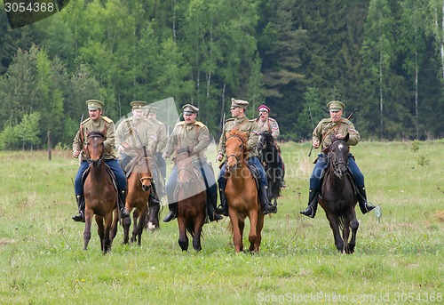 Image of Cavalry soldiers ride on horses across the field