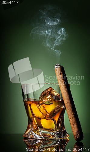 Image of Whiskey and cigar on green