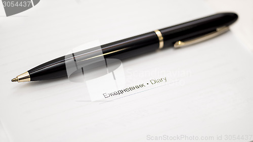 Image of Black ball-point pen and sheet of diary 