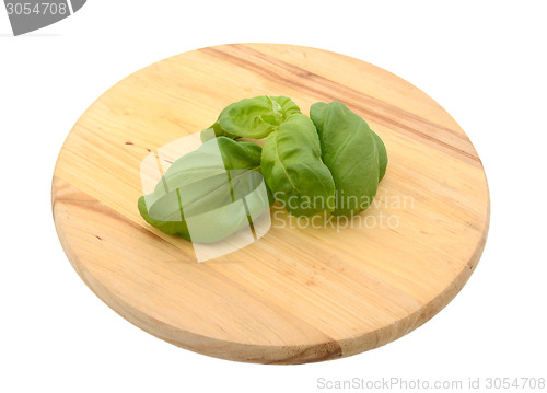 Image of Sprig of fresh basil leaves on a chopping board