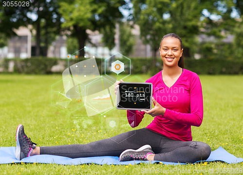 Image of smiling woman with tablet pc outdoors