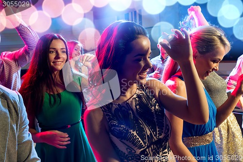 Image of smiling friends dancing in club
