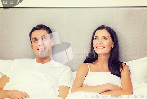Image of happy couple dreaming in bed