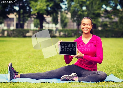 Image of smiling woman with tablet pc outdoors