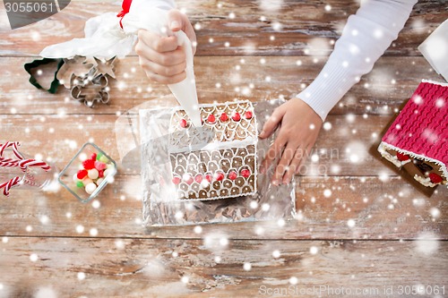 Image of close up of woman making gingerbread houses