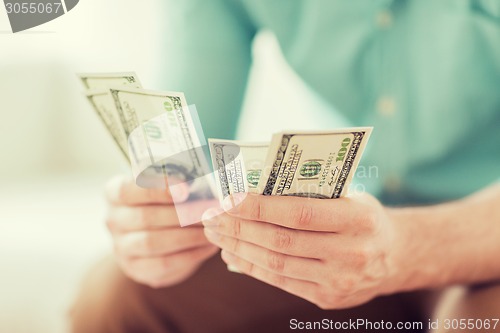 Image of close up of man counting money at home