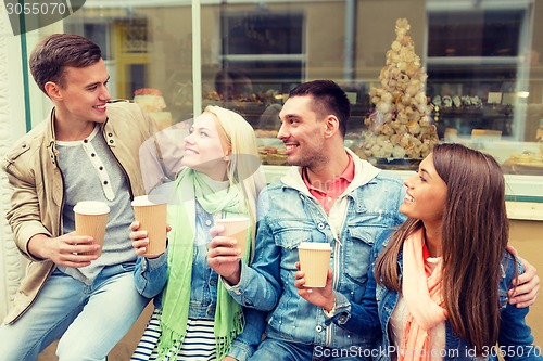 Image of group of smiling friends with take away coffee