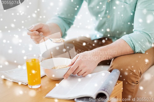 Image of close up of man with magazine eating breakfast