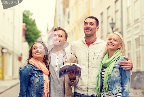 Image of group of friends with city guide exploring town