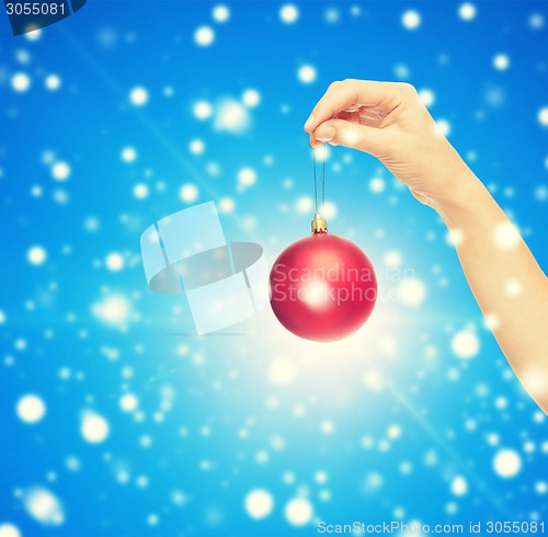 Image of close up of woman in sweater with christmas ball