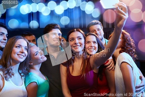 Image of friends with smartphone taking selfie in club