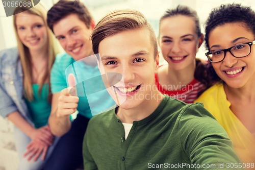 Image of five smiling students taking selfie at school