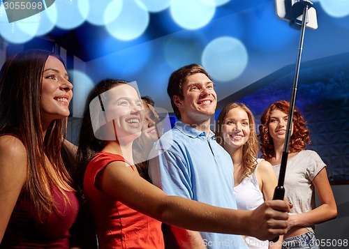 Image of friends with smartphone taking selfie in club