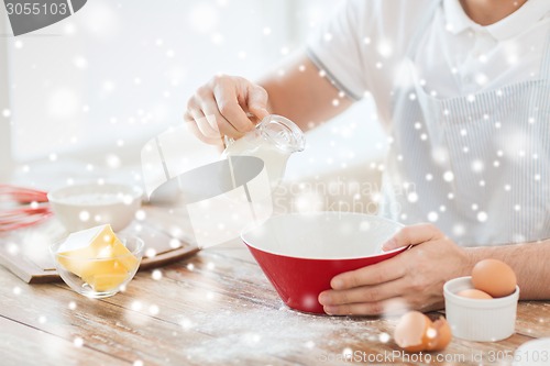 Image of close up of man pouring milk to bowl