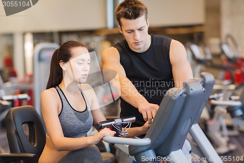 Image of woman with trainer on exercise bike in gym