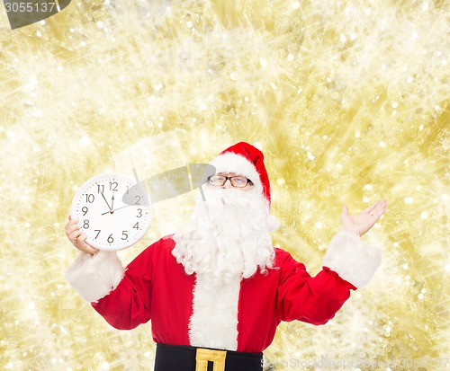 Image of man in costume of santa claus with clock