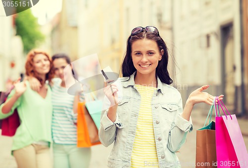 Image of smiling teenage girls with shopping bags on street