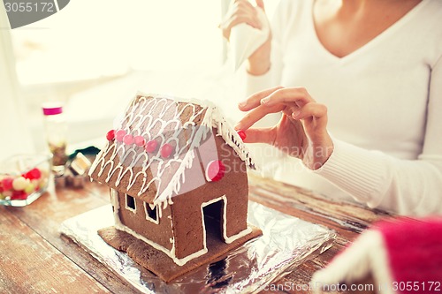 Image of close up of woman making gingerbread houses