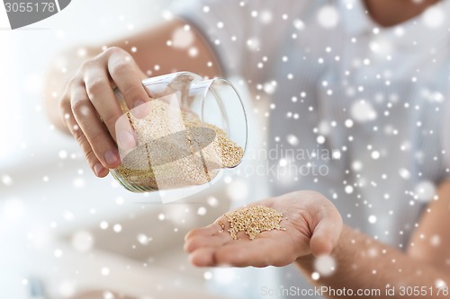 Image of close up of male emptying jar with quinoa