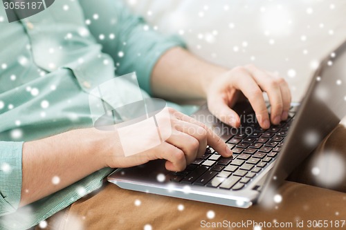 Image of close up of man working with laptop at home