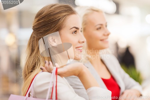 Image of happy young women with shopping bags in mall