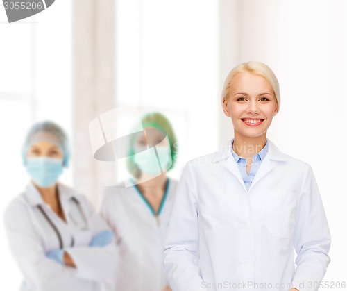 Image of smiling female doctor with group of medics