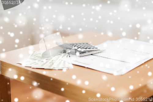 Image of close up of money and calculator on table at home