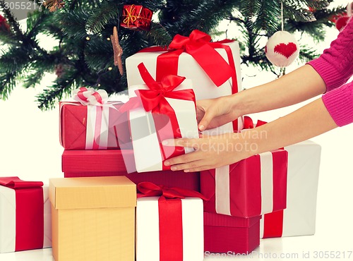 Image of close up of woman with gifts and christmas tree