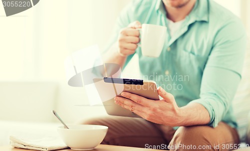 Image of close up of man with tablet pc having breakfast