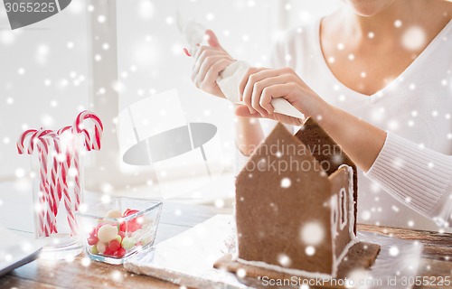 Image of close up of woman making gingerbread houses