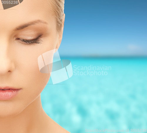 Image of beautiful young woman over blue sky and sea