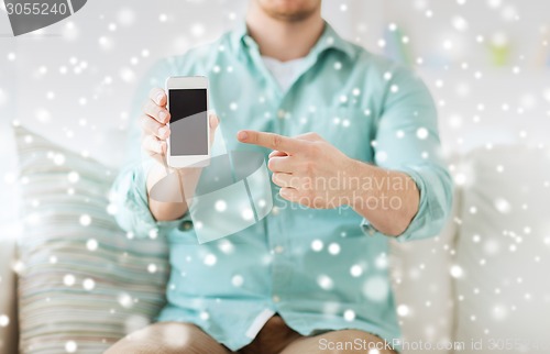 Image of close up of man showing smartphone at home