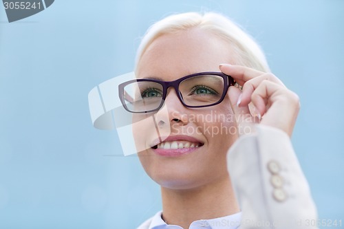 Image of young smiling businesswoman over office building