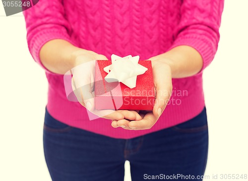 Image of close up of woman in pink sweater holding gift box