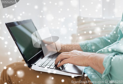 Image of close up of man working with laptop at home