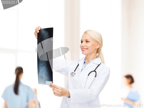 Image of smiling female doctor looking at x-ray image