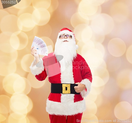 Image of man in costume of santa claus with euro money