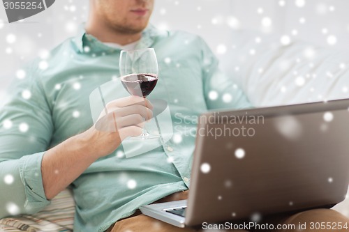 Image of close up of man with laptop and wine glass